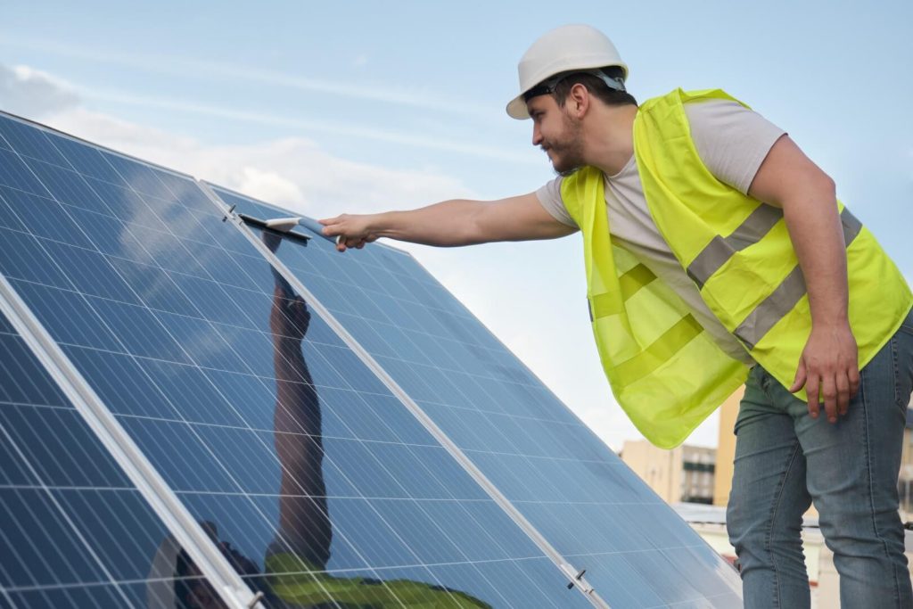 technician-cleaning-solar-panels-with-a-squeegee-tucson-arizona