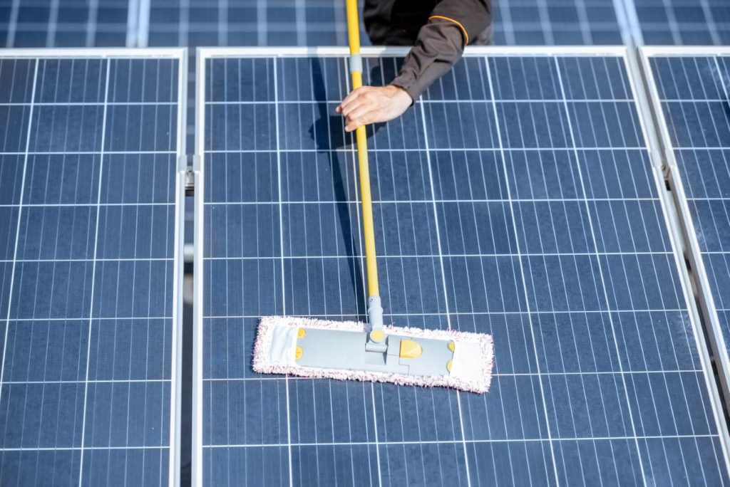 workman-cleaning-solar-panels